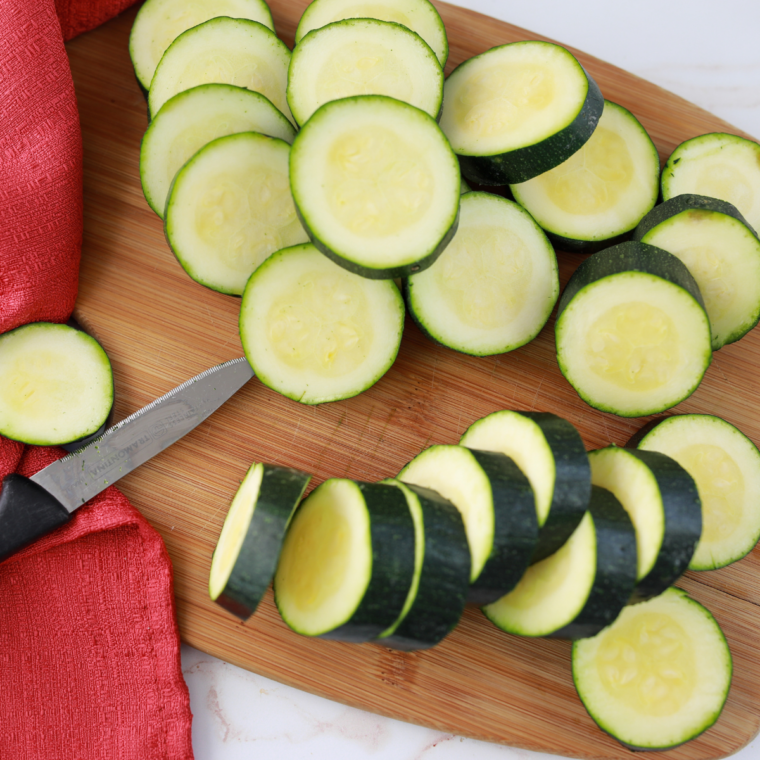 Sliced zucchini rounds resting on a paper towel, salted to draw out moisture