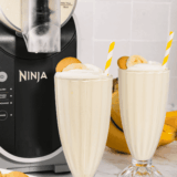 Ninja Slushi Banana Milkshake topped with whipped cream and banana slices