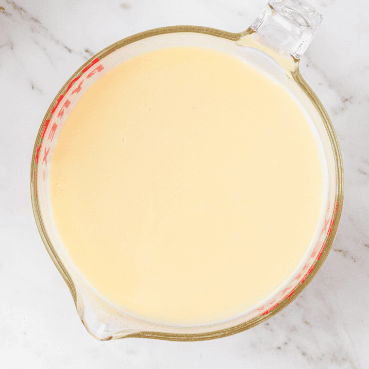 Whisking milk, heavy cream, banana pudding, and sugar in a bowl