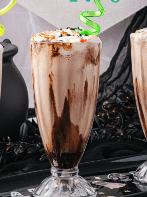 Ninja Slushi chocolate milkshake in a tall glass topped with whipped cream and chocolate syrup