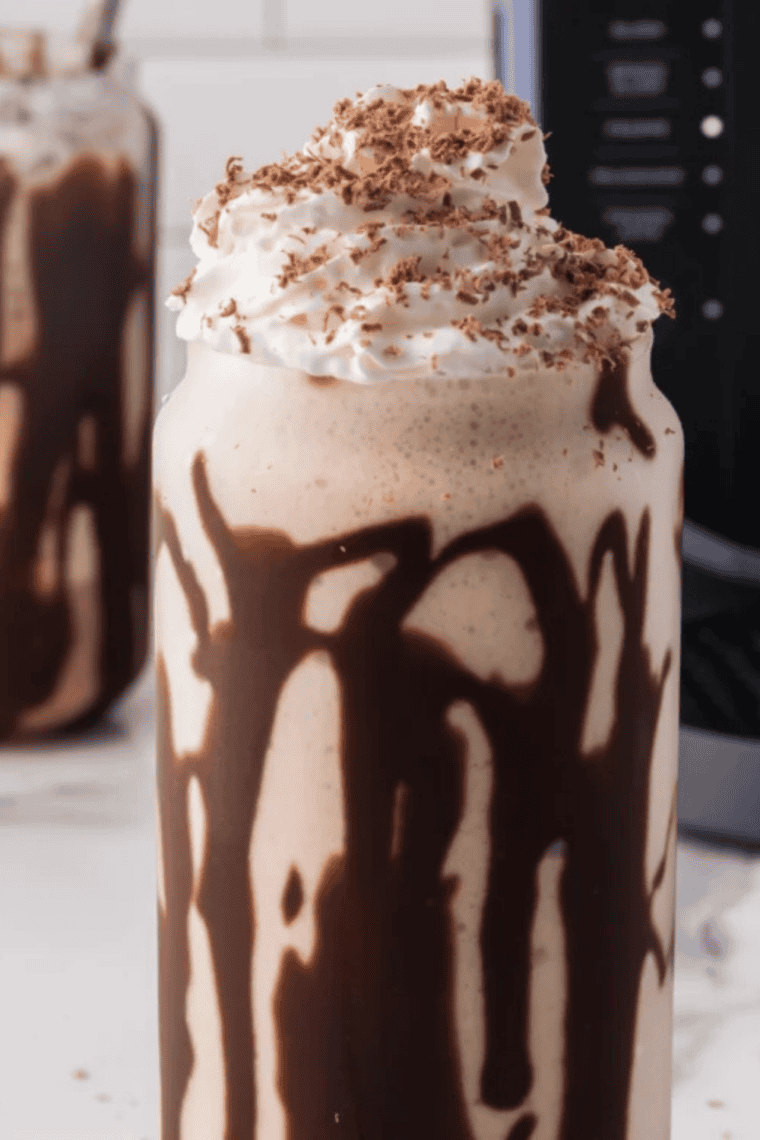 Two Ninja Slushi chocolate milkshakes with whipped cream and chocolate shavings on a marble counter