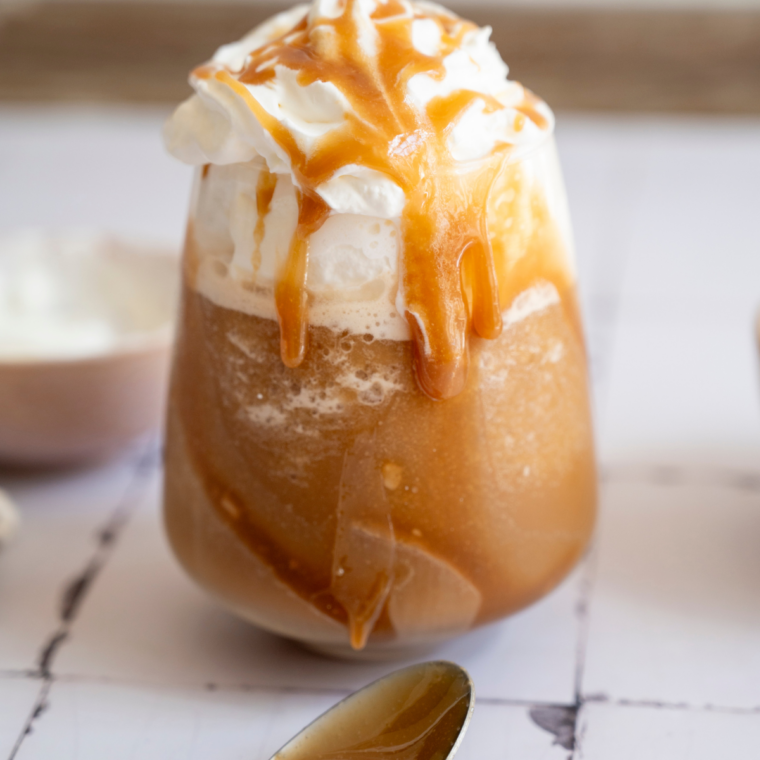 Ninja Slushi mocha frappe in a tall glass topped with whipped cream and chocolate drizzle