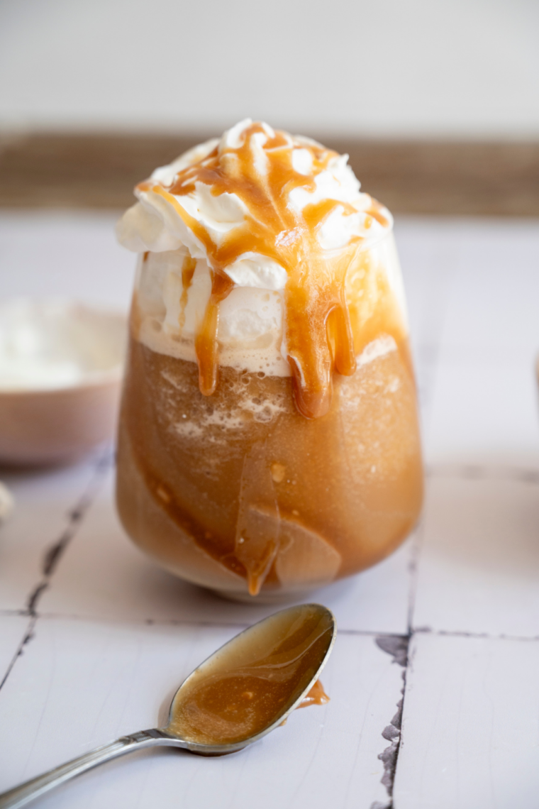 Ninja Slushi mocha frappe in a tall glass topped with whipped cream and chocolate drizzle