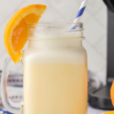 Ninja Slushi Orange Julius recipe served in a tall glass topped with whipped cream and an orange slice