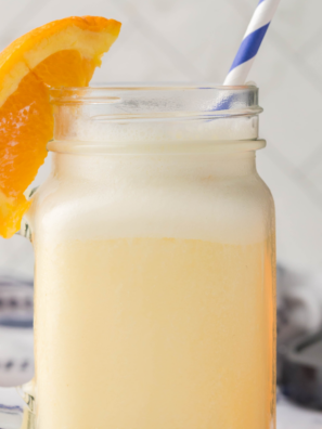 Ninja Slushi Orange Julius recipe served in a tall glass topped with whipped cream and an orange slice