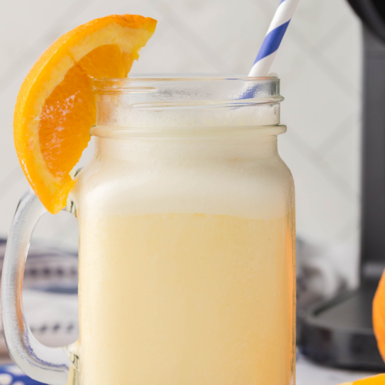 Ninja Slushi Orange Julius recipe served in a tall glass topped with whipped cream and an orange slice