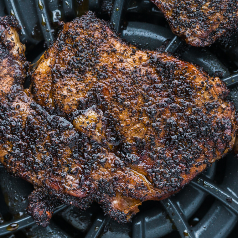 Close-up of a sliced Outlaw Ribeye showing the medium-rare center, seared crust, and bone