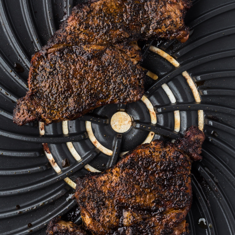 Outlaw Ribeye basted with foaming butter, smashed garlic, and fresh herbs in a cast-iron skillet