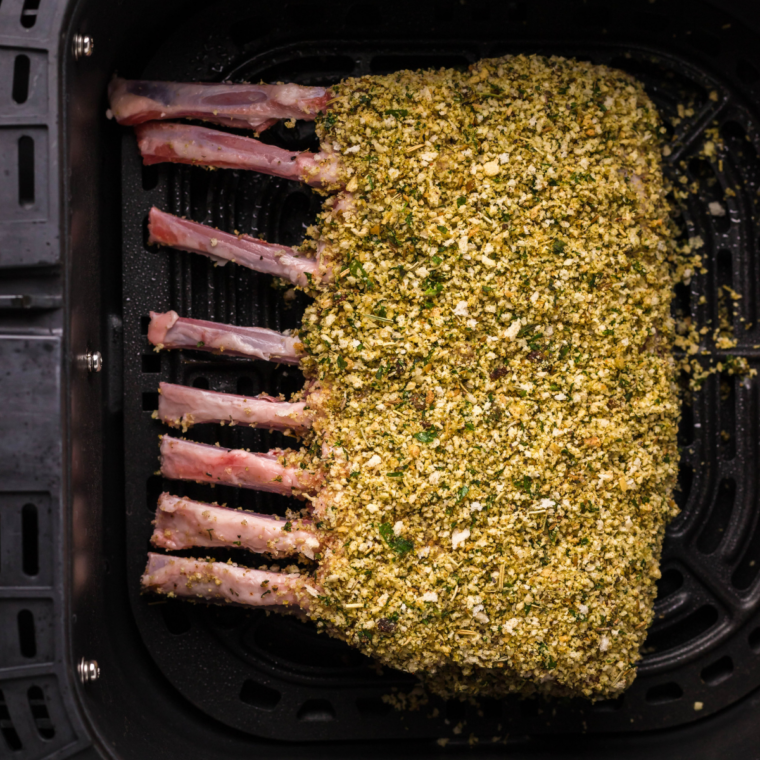 Lamb chops searing to golden brown in a cast iron skillet