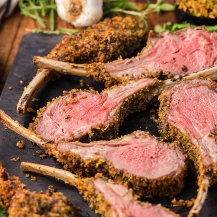 Finished parmesan crusted lamb chops resting on a plate before serving