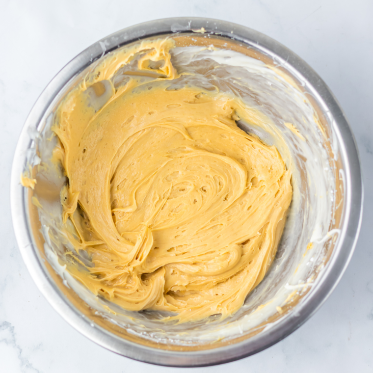 Peanut butter beaten into cream cheese frosting until golden brown and smooth