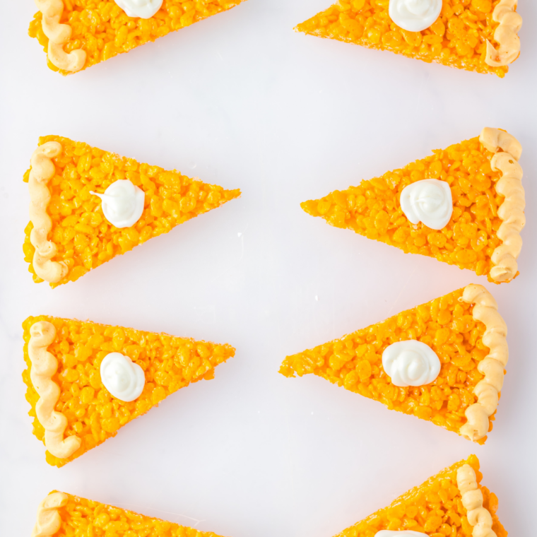 Small dollop of cream cheese frosting piped onto the center of a Rice Krispie pie slice