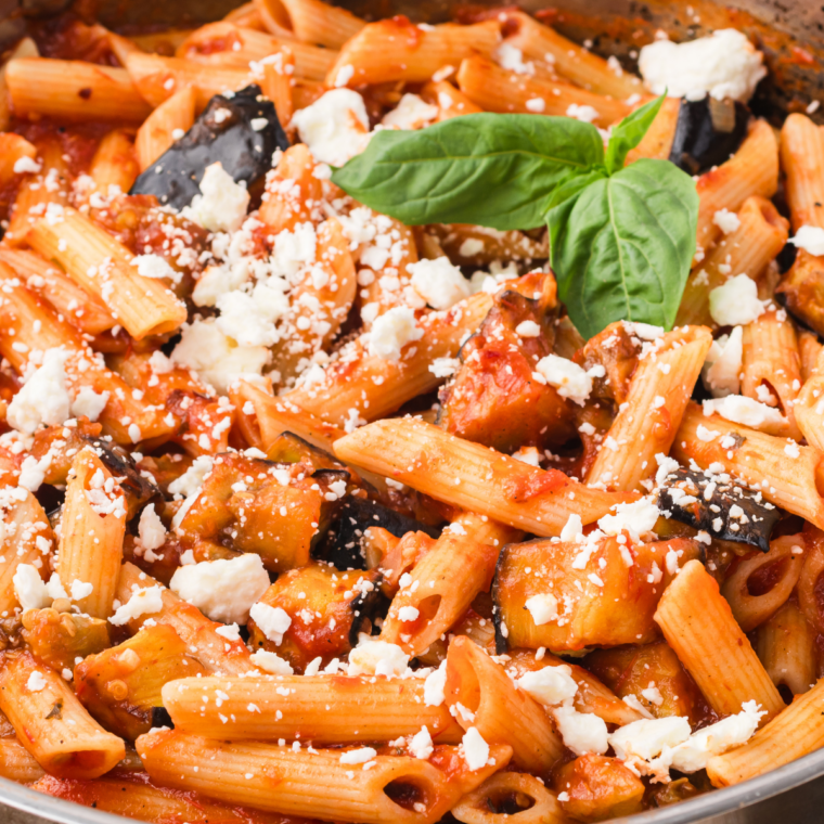 Roasted tomato pasta sauce in a white bowl topped with fresh basil and grated parmesan