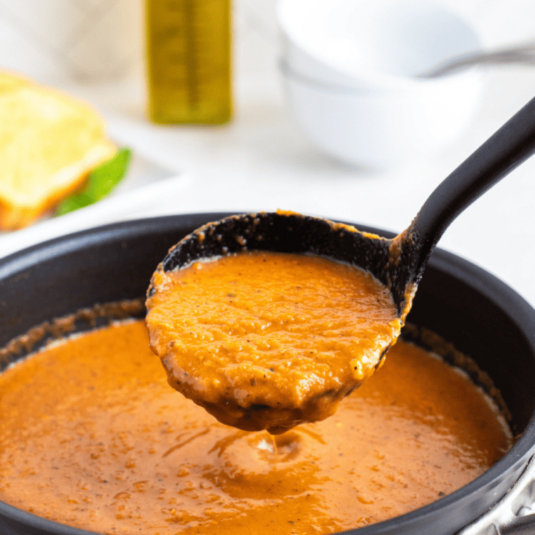 heavy cream swirling into hot pureed tomato soup