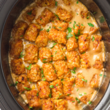 Slow cooker cowboy casserole topped with crispy golden tater tots and melted cheddar cheese