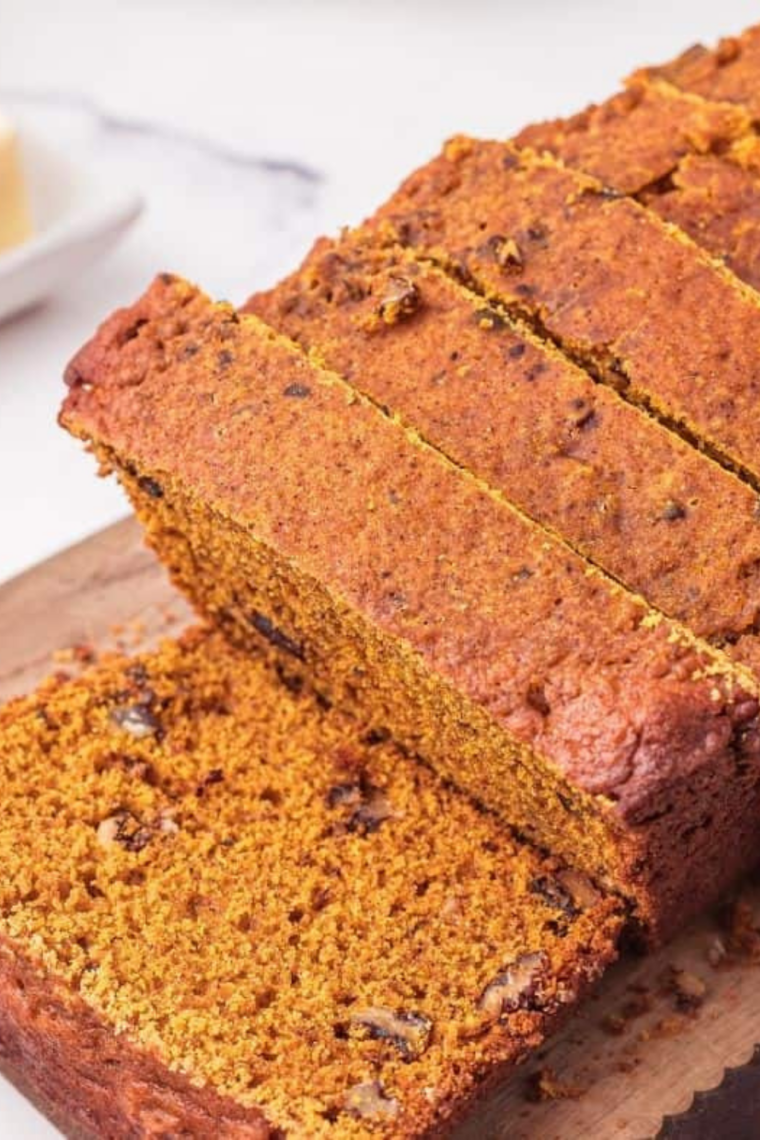 Sliced slow cooker pumpkin bread on a wooden cutting board
