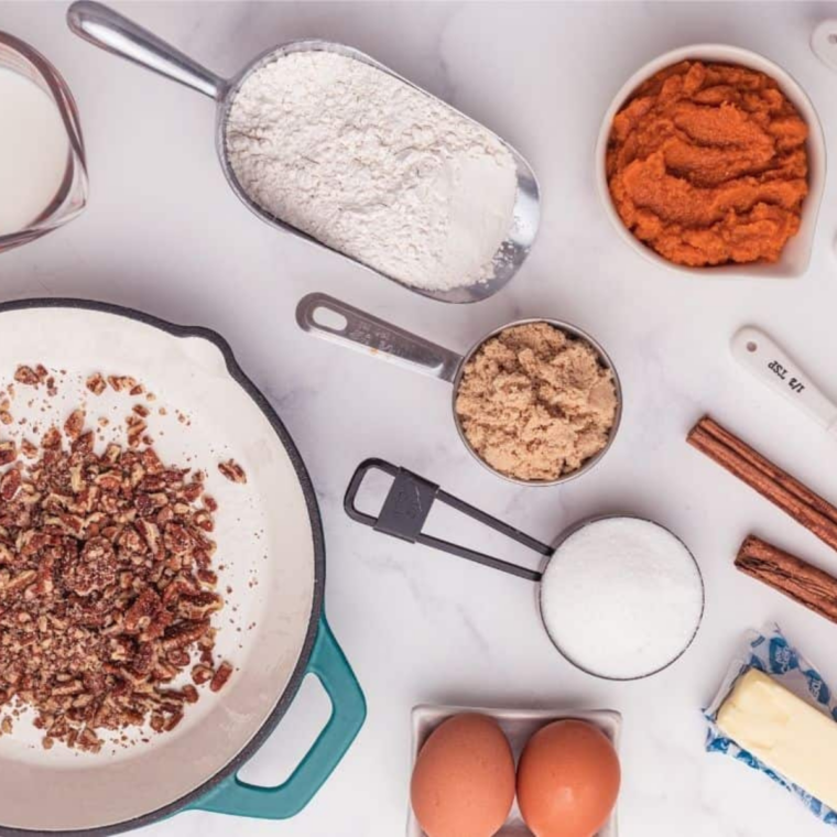 Flat lay of slow cooker pumpkin bread ingredients including canned pumpkin puree, flour, brown sugar and fall spices