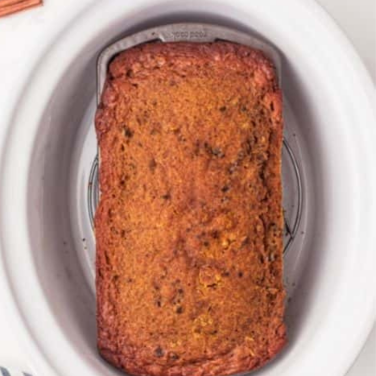 Slow cooker pumpkin bread finished cooking in a white slow cooker