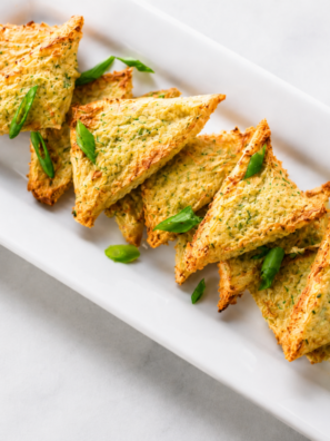 Air fryer shrimp toast triangles topped with golden sesame seeds on a plate