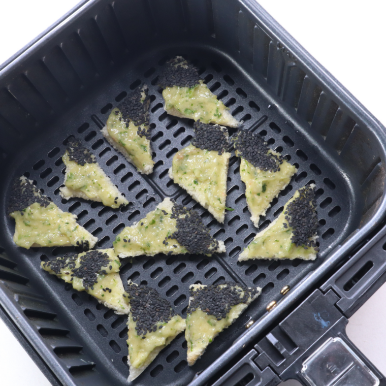 Shrimp toast arranged shrimp-side up in a single layer in the air fryer basket