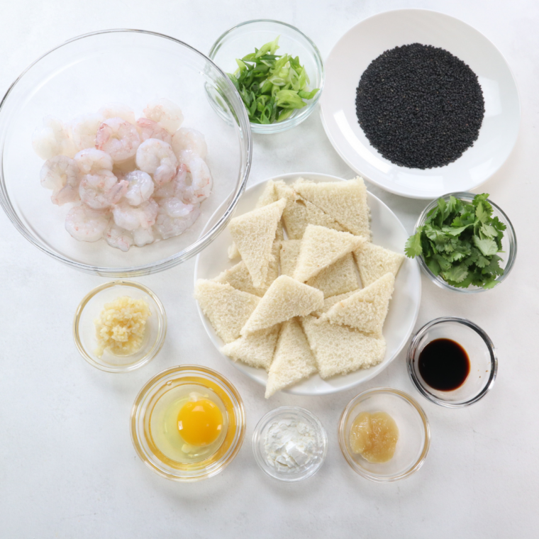 Ingredients for homemade shrimp toast: raw shrimp, bread, green onion, and sesame seeds