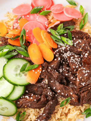 Air fryer bulgogi beef bowl with rice, scallions, sesame seeds, cucumber, and pickled radish