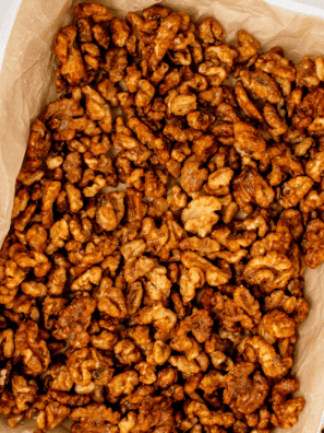 Air fryer candied coffee walnuts cooling in a single layer on a parchment-lined baking sheet