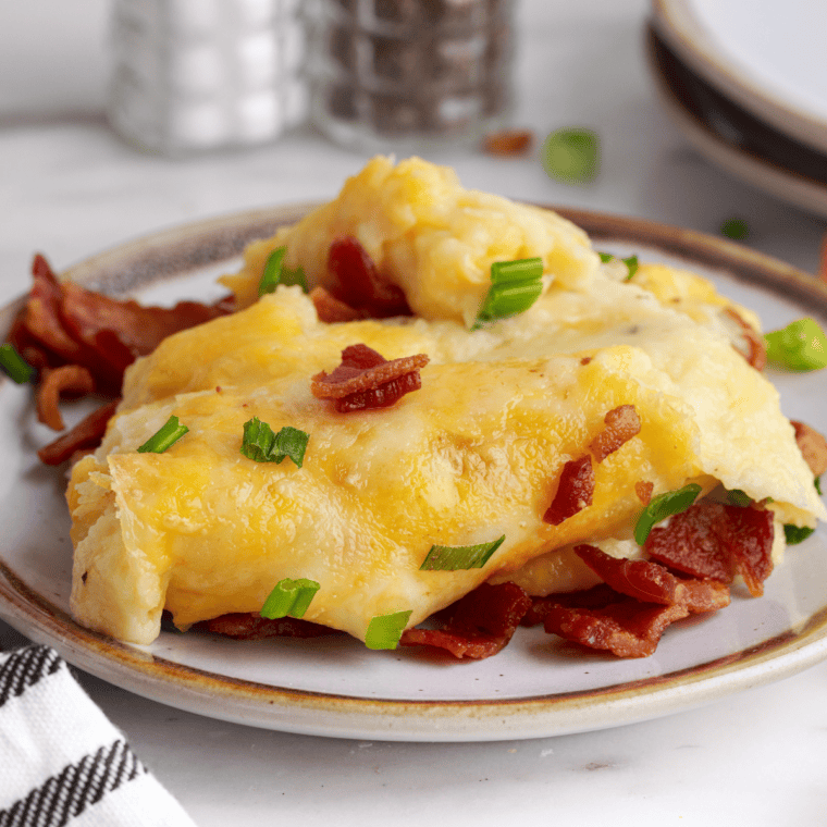 Chives and crumbled bacon sprinkled over melted cheese on finished Chili's loaded mashed potatoes
