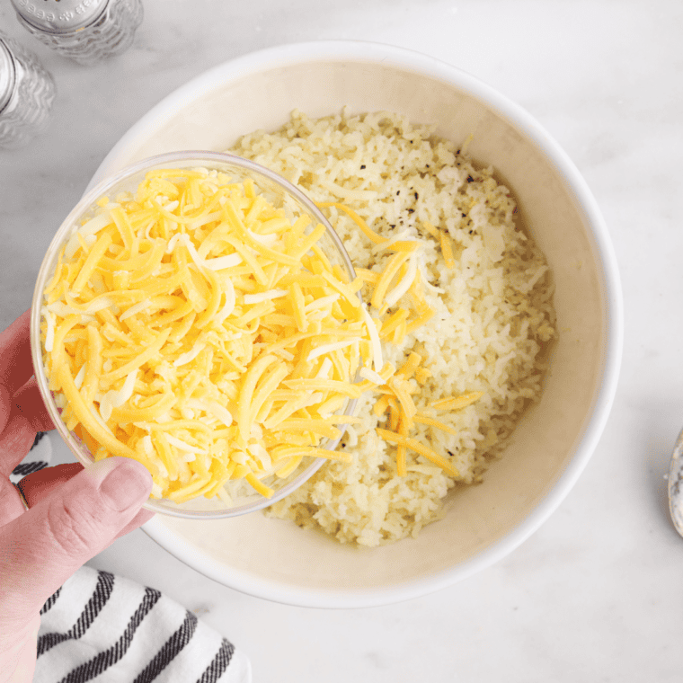 Shredded cheddar and Monterey Jack scattered over mashed potatoes in a 9x13 baking dish before broiling
