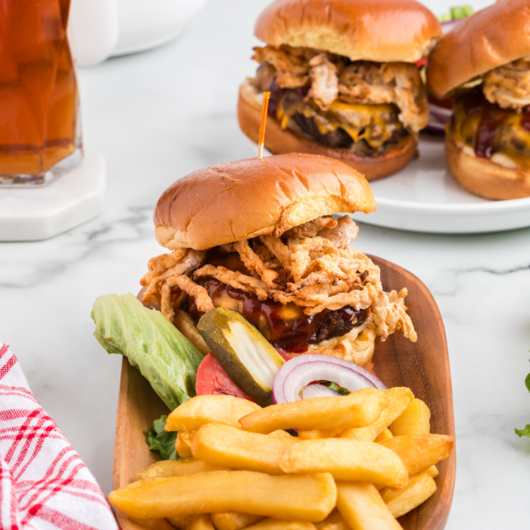 air fryer copycat French's fried onions piled on a whiskey BBQ burger with steak fries