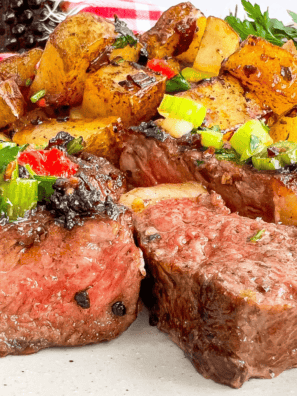 Grilled ribeye on a plate coated in homemade buttery garlic and herb seasoning with a sprig of thyme