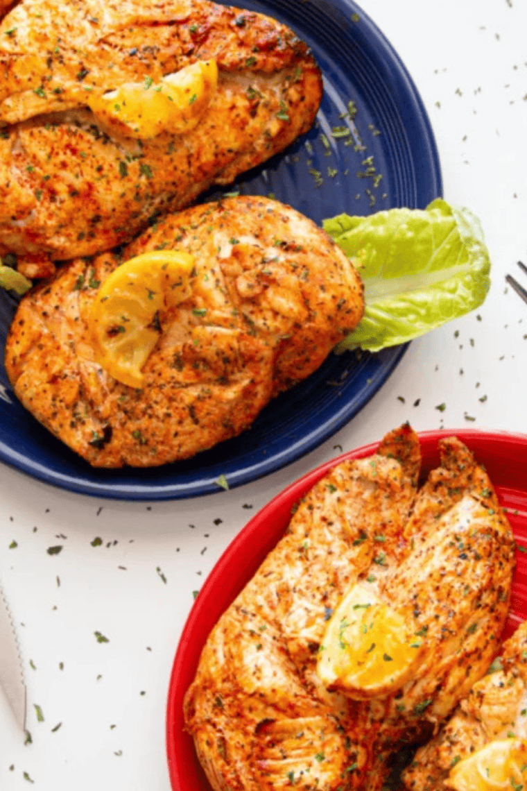 Copycat Kinder's lemon pepper seasoning sprinkled over raw chicken breasts