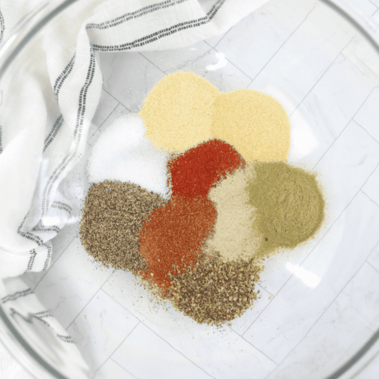 Spices whisked together in a bowl into an even brick-red seasoning blend