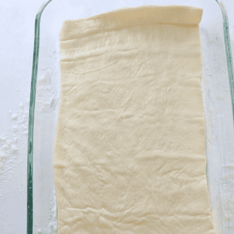 Dough pressed to the edges of an oiled 9x13 metal baking pan