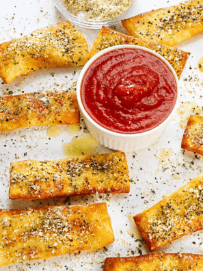 Pizza Hut cheese sticks recipe: pan-baked cheesy breadsticks pulled apart to show melted mozzarella, with a bowl of marinara