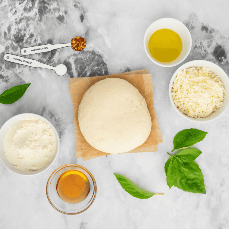 Ingredients for Pizza Hut cheese sticks on a table: bread flour, yeast, mozzarella, parmesan, butter, and seasonings