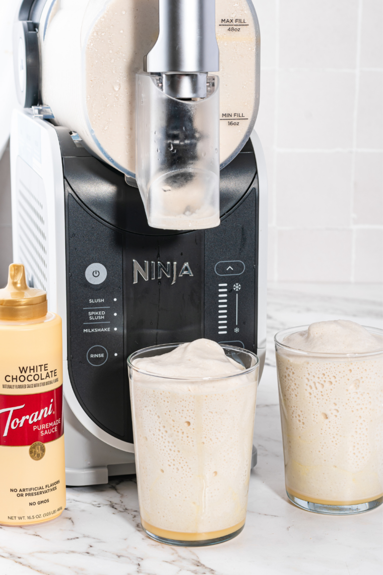 Thick caramel Frosty dispensing from the Ninja Slushi spout into a clear cup