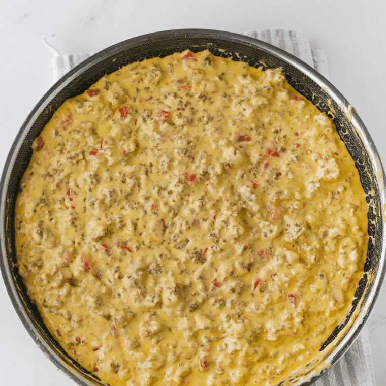 Football dip partway through melting, still lumpy before the cheese turns smooth