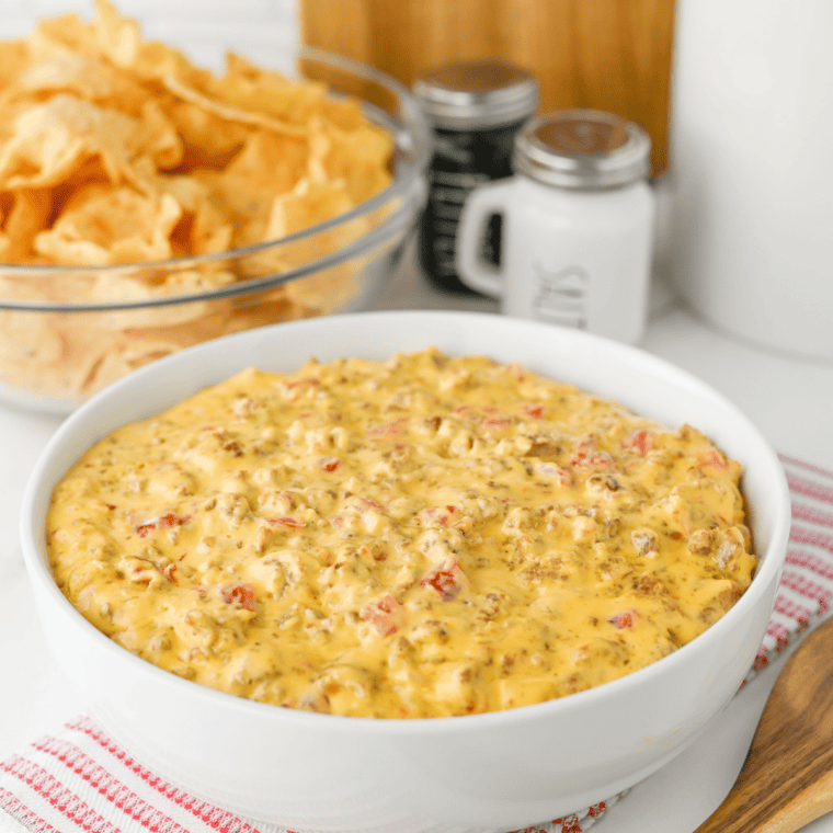 Football dip in a black skillet surrounded by tortilla chips on a wood board