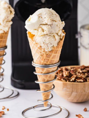 Ninja Creami Copycat Baskin Robbins Old Fashioned Butter Pecan ice cream in a waffle cone with toasted pecans