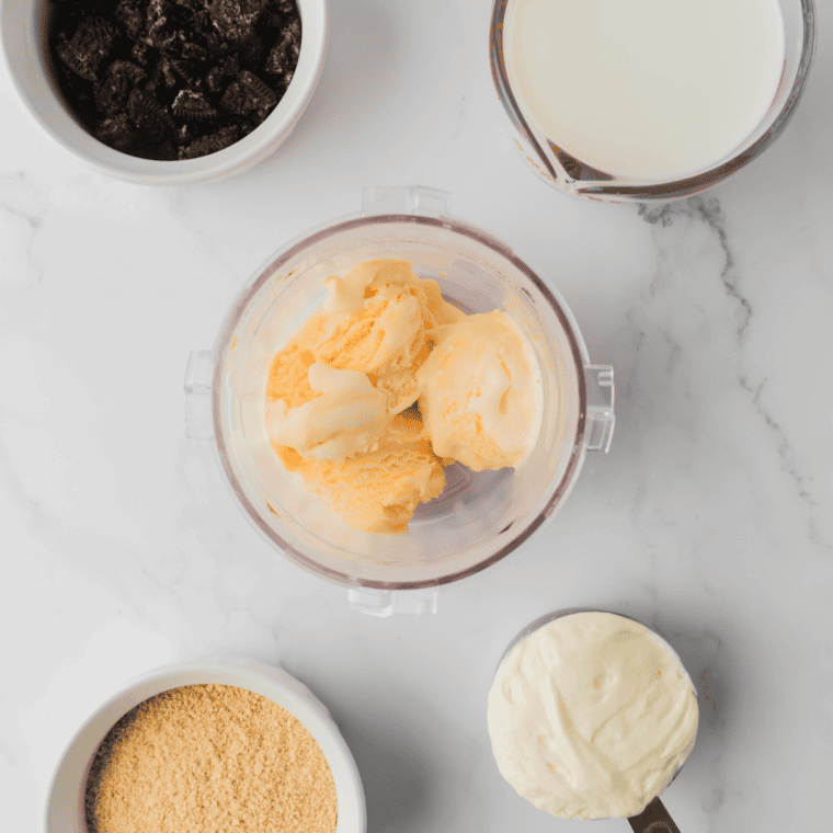 Ingredients for Ninja Creami Copycat Sonic Oreo Cheesecake Milkshake: vanilla ice cream, cheesecake filling, whole milk, crushed Oreos, and graham crackers