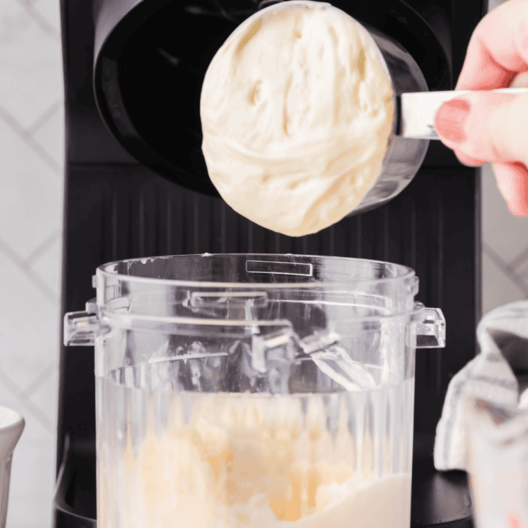 Vanilla ice cream, cheesecake filling, and whole milk added to a Ninja Creami pint container below the max fill line