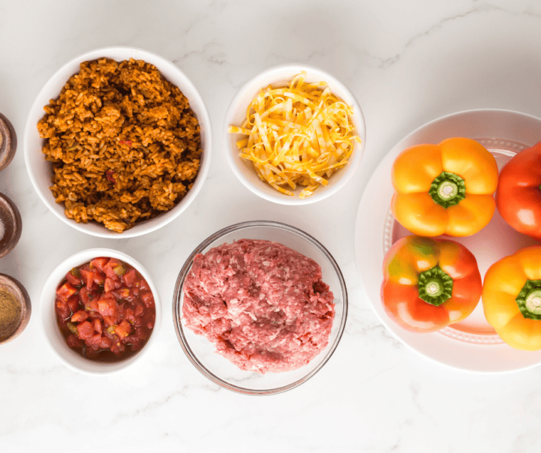 Ingredients for Ninja Crispi stuffed peppers: bell peppers, ground beef, Spanish rice, cheese, and spices