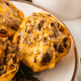 Ninja Crispi stuffed peppers with melted Colby Jack cheese in the glass air fryer container, ready to serve
