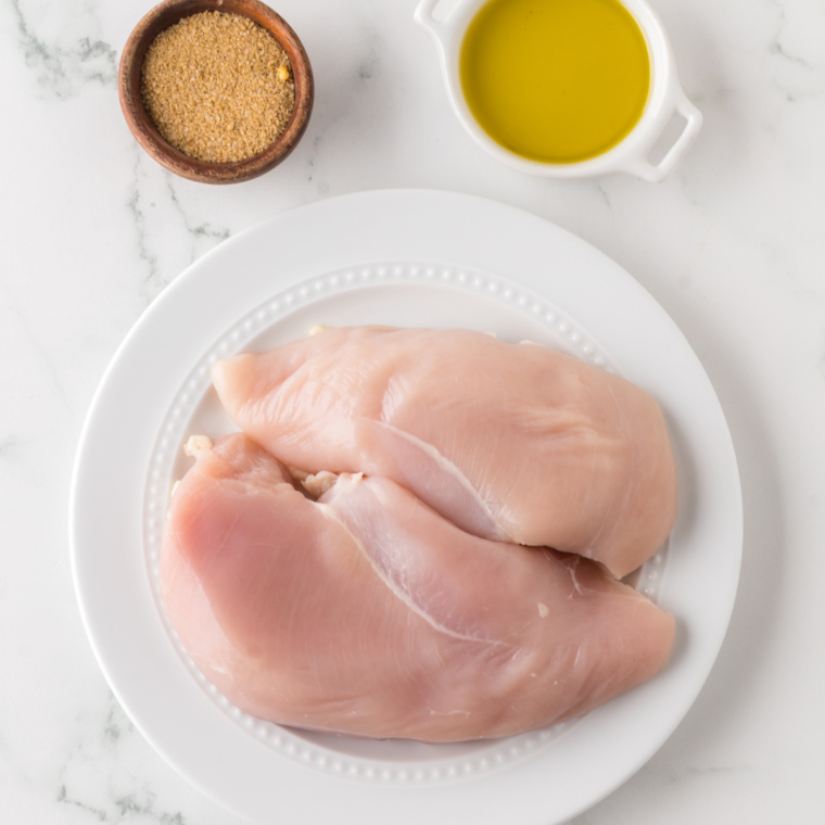 Raw netted turkey breast surrounded by kosher salt, butter, garlic powder, smoked paprika, and dried thyme