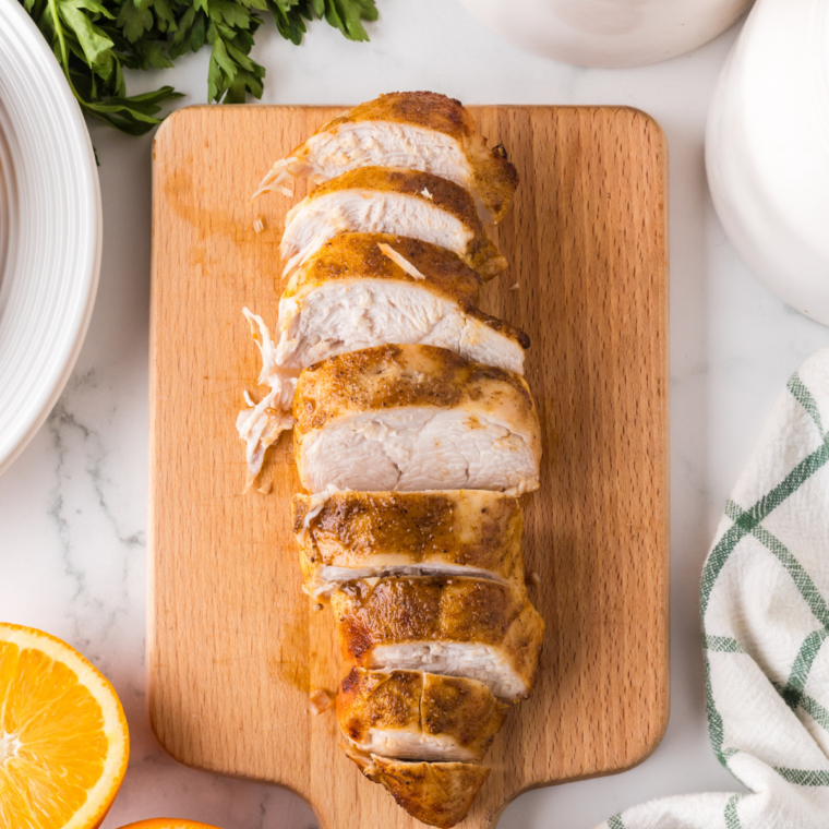 Sliced Ninja Crispi turkey breast with golden crispy skin on a wooden cutting board