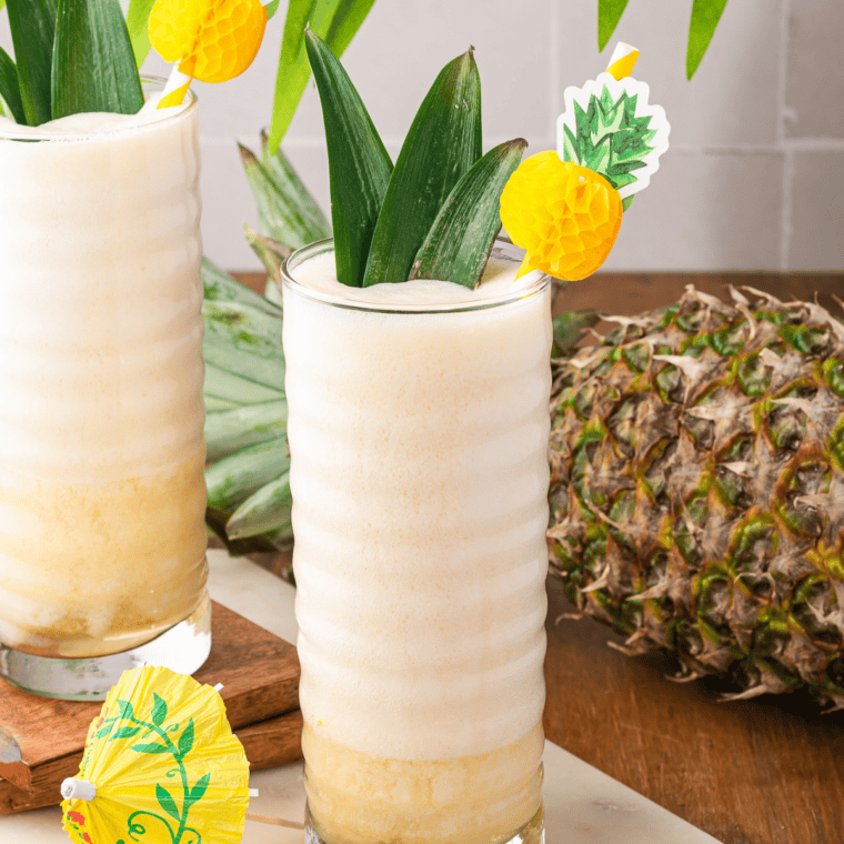 Ninja Slushi Dole Whip in a tall glass with a pineapple frond garnish