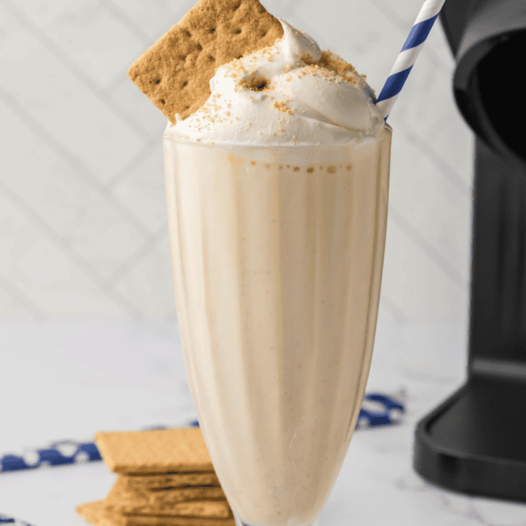 Thick vanilla milkshake made in the Ninja Slushi, poured into a tall glass with a wide straw