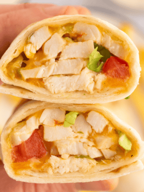 Air fryer chicken snack wrap cut in half showing shredded chicken, melted cheddar, and ranch inside a crispy golden tortilla
