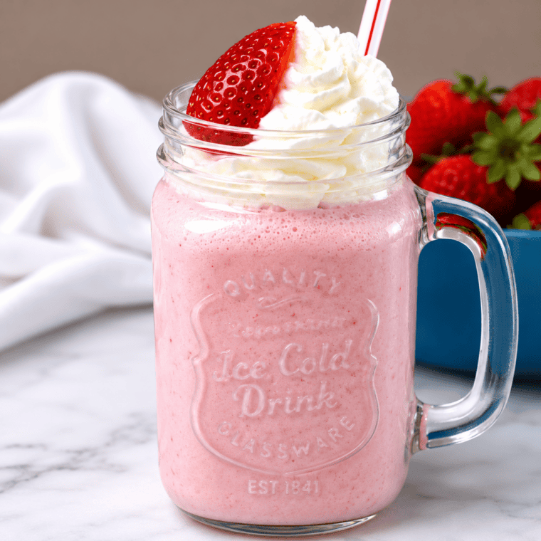 Pouring strawberry milkshake base into the Ninja Slushi between the fill lines